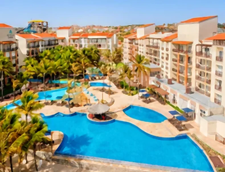 Resort com piscinas entre coqueiros, vista do alto